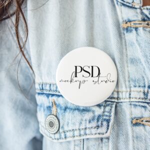 A person in a light blue denim jacket with a round "PSD mockup studio" button stands next to the White 5x7 Frame Mockup with Linen | Real Photo PSD, creating a stylish and creative scene.