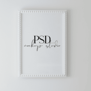 The White A4 Frame Wall Hung, from the Wall Hung Minimal PSD collection, decorates a light wall. "PSD mockup studio" is displayed in black, elegant fonts on a plain white background inside the frame.